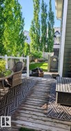 Spacious outdoor deck with a wooden surface, white railing, and direct access to a fenced yard - 