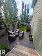 Expansive stamped concrete patio with direct backyard access from wood stairs - 