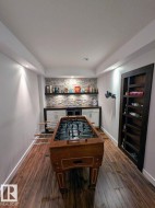 Recreation room featuring wood-finish flooring, recessed lighting, and a stone accent wall - 
