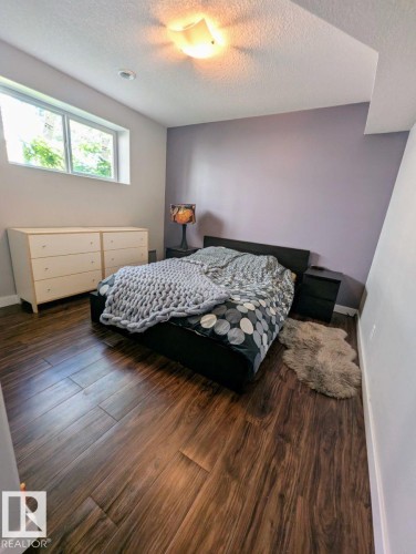 Interior room featuring wood-finish flooring, a wall-mounted light fixture, recessed ceiling lighting, and a horizontal window - 2327 Frezenberg Avenue, Edmonton, AB 
