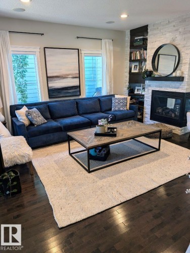 Living area with dark wood-finish flooring, recessed lighting, and large windows - 2327 Frezenberg Avenue, Edmonton, AB 