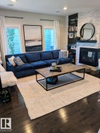 Living area with dark wood-finish flooring, recessed lighting, and large windows - 
