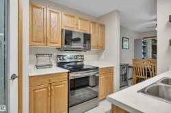 Kitchen featuring wood-finish cabinetry, white countertops, a stainless steel range, and an over-the-range microwave - 