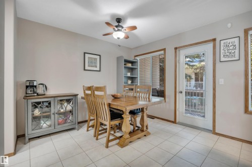 Dining space featuring light tile flooring and natural wood trim - 207-4807 43A Ave, Leduc, AB 
