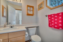 Bathroom featuring a light-toned vanity with an integrated sink, a matching countertop, and a toilet. - 