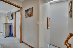 Carpeted hallway with wood trim and white paneled doors - 