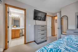 Carpeted bedroom area featuring light-toned walls and wood-trimmed doorways - 