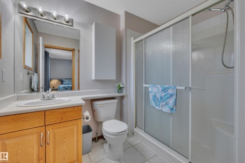Bathroom featuring a single vanity with wood cabinetry, a white countertop, and a mirrored medicine cabinet - 207-4807 43A Ave, Leduc, AB 