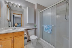 Bathroom featuring a single vanity with wood cabinetry, a white countertop, and a mirrored medicine cabinet - 