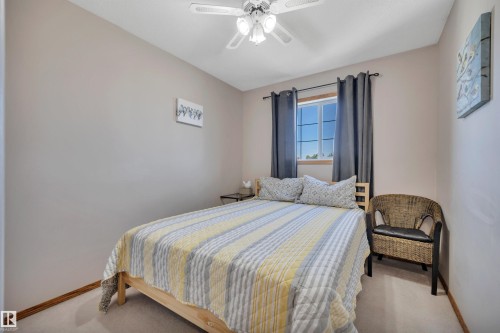 Carpeted room featuring a ceiling fan with integrated lighting, a window with horizontal muntins, and neutral-toned walls - 207-4807 43A Ave, Leduc, AB 