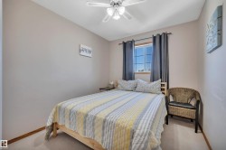Carpeted room featuring a ceiling fan with integrated lighting, a window with horizontal muntins, and neutral-toned walls - 