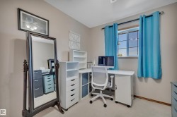 Neutral tone wall color with a framed artwork, ceiling light fixture, and window with light blue curtains - 