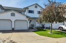 White siding exterior with a one-car garage, concrete driveway, and a front entrance porch - 207-4807 43A Ave, Leduc, AB 