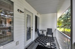 Covered patio featuring white horizontal siding and a white railing - 