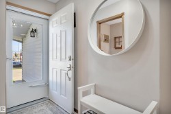 Entryway featuring a paneled door, storm door, and neutral wall paint - 