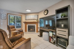 Living room featuring a gas fireplace with a wood mantle, tile flooring, and corner window. - 
