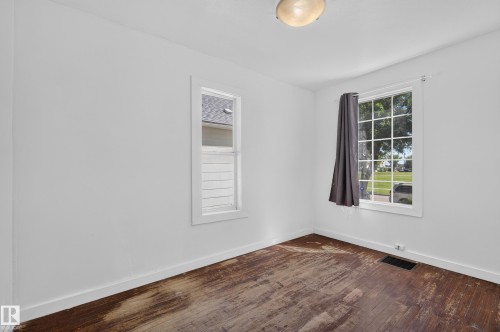 Room featuring white walls, two windows, and a ceiling-mounted light fixture - 11708 79 Street, Edmonton, AB 