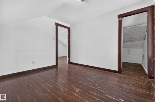 Spacious attic room with white painted walls and wood-finish flooring - 11708 79 Street, Edmonton, AB 