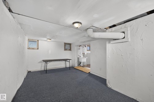Carpeted lower level with white-painted walls and exposed ceiling elements - 11708 79 Street, Edmonton, AB 