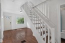 Staircase with white balusters and wood-finish treads, complemented by dark wood-finish flooring - 11708 79 Street, Edmonton, AB 
