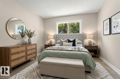 The virtual staging emphasizes the room's clean lines and natural light from the window while creating a serene, uncluttered atmosphere; thoughtful furniture placement help buyers envision this as their own restful sanctuary - 10602 100 Avenue, Fort Saskatchewan, AB - Indoor Photo Showing Bedroom