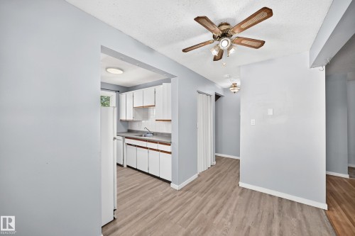 Open concept living space featuring wood-finish flooring, a ceiling fan with integrated lighting, and light blue wall tones - 355 Northgate Terrace, Edmonton, AB 