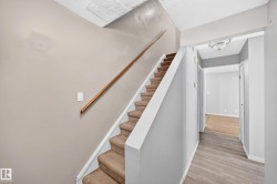 Carpeted staircase with wood handrail - 