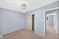 Room featuring neutral carpeting, light blue wall paint, and a textured ceiling - 