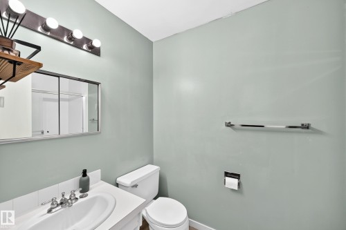 Bathroom featuring a white ceramic sink with chrome faucet, a mirrored medicine cabinet, and a five-bulb vanity light fixture - 355 Northgate Terrace, Edmonton, AB 
