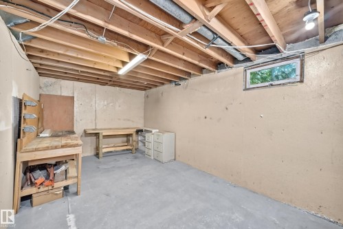 Unfinished basement featuring exposed wood joists, concrete flooring, and a small egress window - 355 Northgate Terrace, Edmonton, AB 