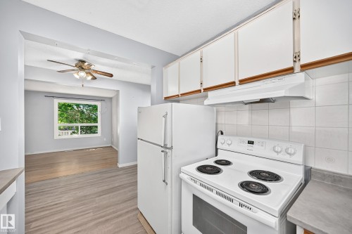 Kitchen featuring white cabinetry, white tile backsplash, an electric range, and a white refrigerator - 355 Northgate Terrace, Edmonton, AB 
