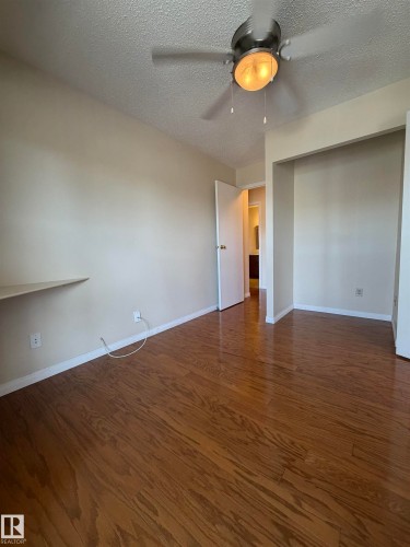 Bright interior space featuring wood-finish flooring, neutral-toned walls, and a ceiling fan with integrated lighting - 2324 151 Avenue Nw, Edmonton, AB - Indoor Photo Showing Other Room