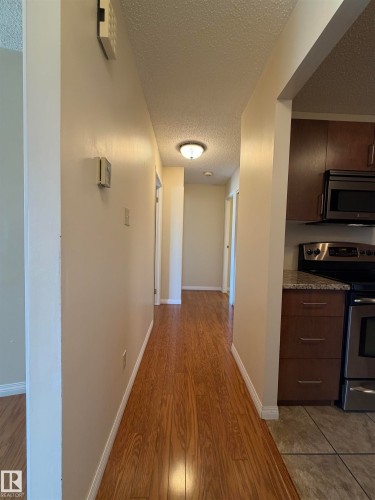 Hallway with wood-finish flooring, neutral wall paint, and a flush-mount ceiling light - 2324 151 Avenue Nw, Edmonton, AB - Indoor