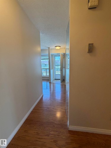 Warm wood-finish flooring extending through an interior corridor - 2324 151 Avenue Nw, Edmonton, AB - Indoor Photo Showing Other Room