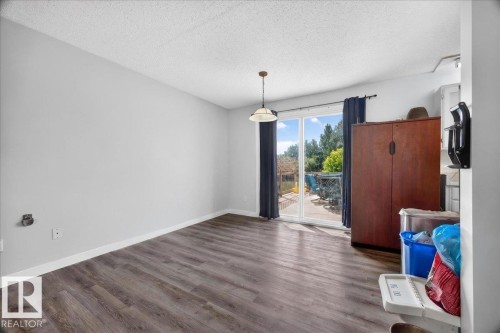 Spacious room featuring wood-finish flooring, light gray walls, and white baseboards - 5215 50 Avenue, Bruderheim, AB - Indoor Photo Showing Other Room