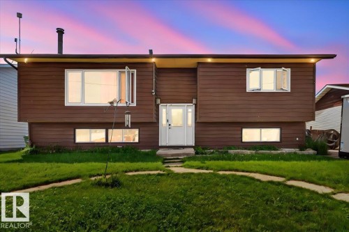 Brown horizontal siding exterior with a white main entry door and sidelights - 5215 50 Avenue, Bruderheim, AB - Outdoor With Exterior