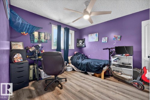 Room featuring wood-finish flooring, a ceiling fan, and a window with dark curtains - 5215 50 Avenue, Bruderheim, AB - Indoor Photo Showing Bedroom