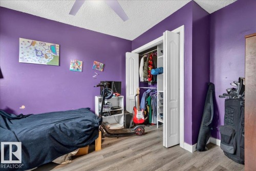 Room featuring wood-finish flooring, a ceiling fan, and a bi-fold closet with interior shelving - 5215 50 Avenue, Bruderheim, AB - Indoor Photo Showing Bedroom