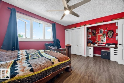 Spacious room featuring wood-finish flooring, a contemporary ceiling fan with integrated lighting, and multiple windows - 5215 50 Avenue, Bruderheim, AB - Indoor Photo Showing Bedroom