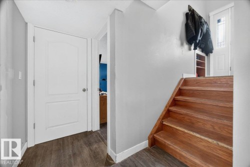 Wood-finish flooring complementing a white paneled door - 5215 50 Avenue, Bruderheim, AB - Indoor Photo Showing Other Room