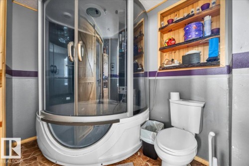 Modern corner shower enclosure with curved glass doors and integrated tub - 5215 50 Avenue, Bruderheim, AB - Indoor Photo Showing Bathroom
