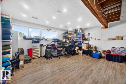 Spacious lower level featuring wood-finish flooring, recessed lighting, and multiple windows - 5215 50 Avenue, Bruderheim, AB - Indoor