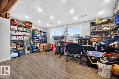 Finished basement space featuring wood-finish flooring and recessed lighting - 5215 50 Avenue, Bruderheim, AB - Indoor