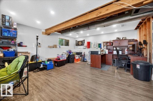 Finished lower level featuring wood-finish flooring, exposed wood beams, recessed lighting, and a visible window - 5215 50 Avenue, Bruderheim, AB - Indoor