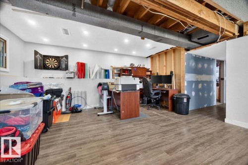 Partially finished basement featuring wood-finish flooring, recessed lighting, and exposed ceiling joists - 5215 50 Avenue, Bruderheim, AB - Indoor Photo Showing Basement