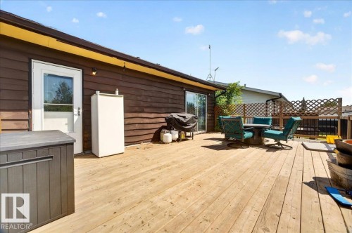 Expansive wood deck with a full-light entry door and a sliding glass door - 5215 50 Avenue, Bruderheim, AB - Outdoor With Deck Patio Veranda With Exterior