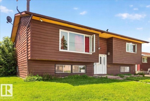 Brown horizontal siding exterior with a bright yellow soffit and white trim - 5215 50 Avenue, Bruderheim, AB - Outdoor With Exterior