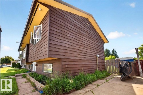 Two-story property featuring horizontal wood siding, a light-colored soffit, and multiple casement windows - 5215 50 Avenue, Bruderheim, AB - Outdoor With Exterior