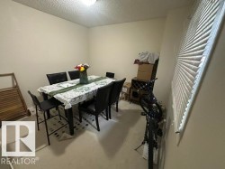 Carpeted room with a ceiling-mounted light fixture and a window featuring horizontal blinds - 