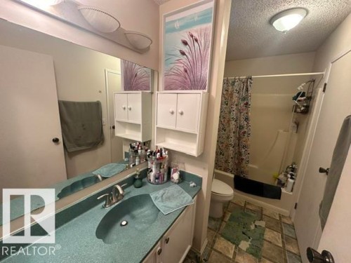 Bathroom featuring a vanity with an integrated basin and a full-width mirror - 18020 96 Avenue, Edmonton, AB 